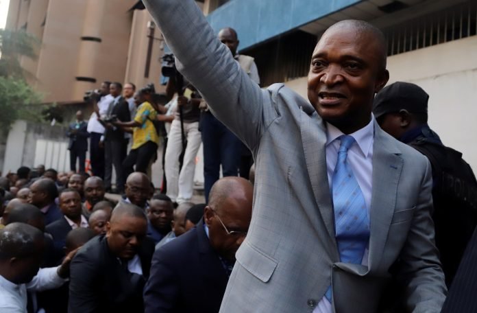 Former Congolese interior minister Emmanuel Ramazani Shadary waves to his supporters as he arrives to file his candidacy for the presidential election, at the Congo's electoral commission head offices in Kinshasa